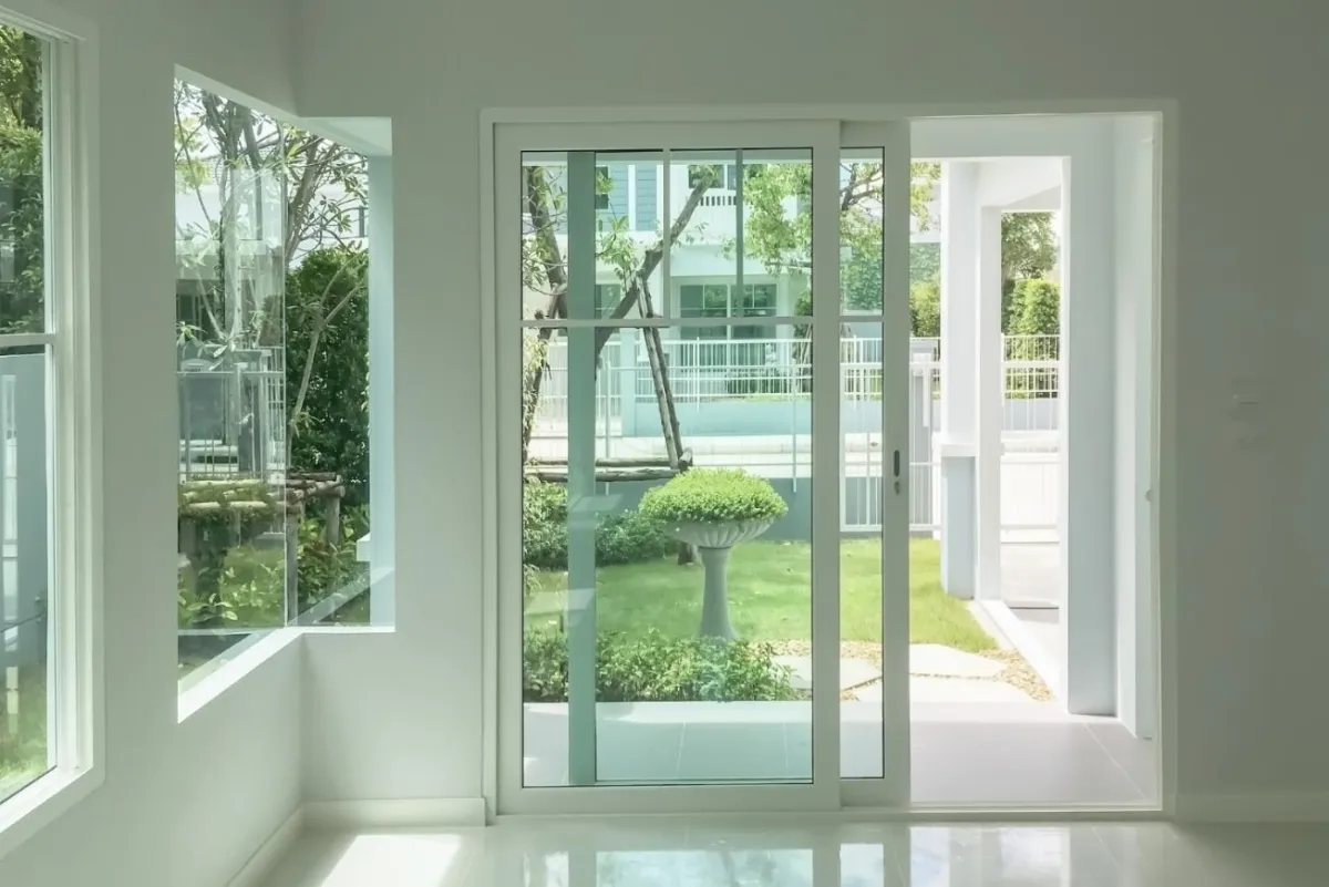 White sliding patio door overlooking a garden