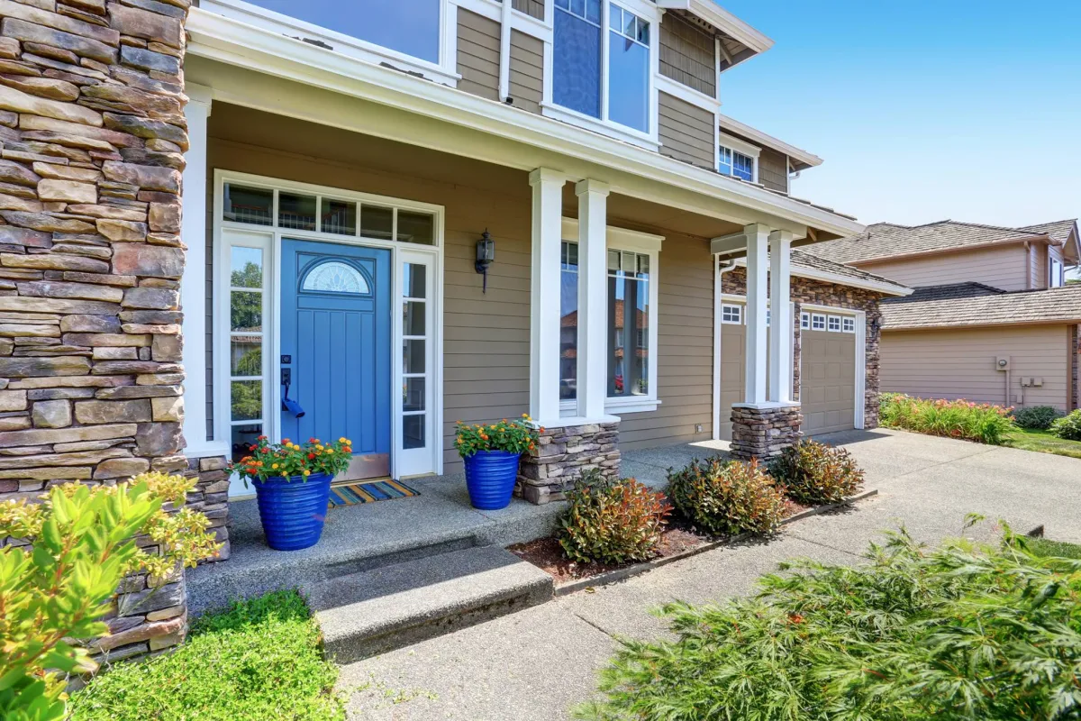 Home exterior with white-framed windows and a blue front door