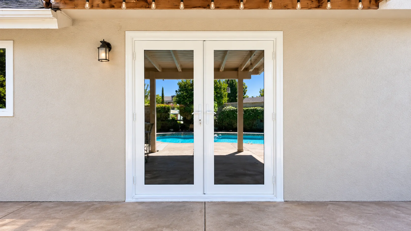 White French patio doors with a swimming pool reflected in the glass